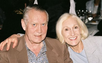 Chuck and Helga Feeney. A man and woman sit side by side, smiling.